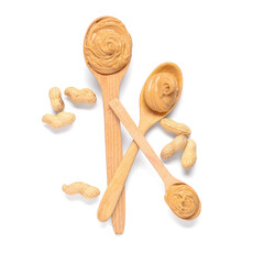 Wooden spoons with tasty peanut butter and nuts on white background