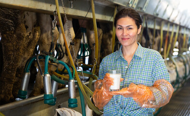 Farm worker standing with glass of fresh milk