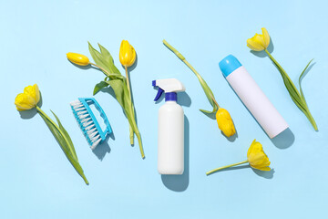Cleaning supplies with spring flowers on blue background