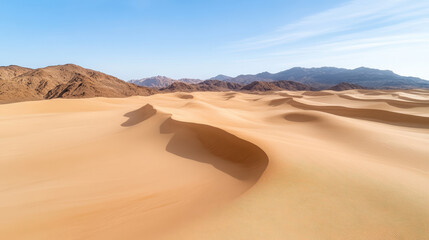 Aerial view of sprawling desert landscape with golden dunes and mountains