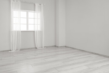 View of big empty room with window and curtains