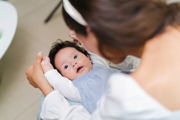 Mother holding and playing with her newborn baby, affection, touch and stimulation