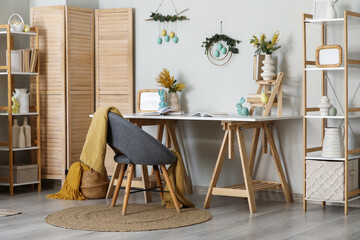 Interior of office decorated for Easter with workplace and shelf units