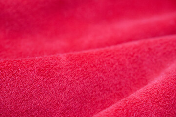 Red silk velvet close up with selective focus. Abstract defocused background