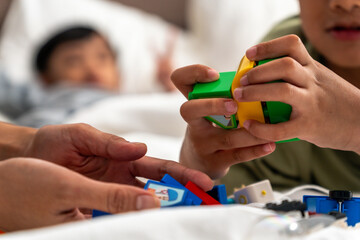 Fototapeta premium Siblings playing with their favorite toys on the bed before bedtime