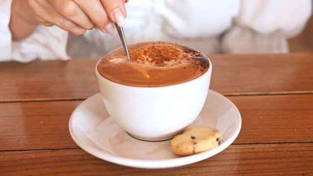 Captivating latte art on frothy cappuccino Coffee culture meets artistry in warm caft setting where skilled barista crafts intricate design on velvety foam elevating experience Coffee theme concept