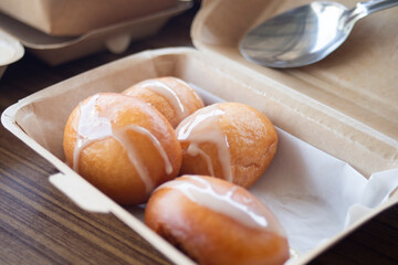 Close up of freshly baked donuts with white icing and sugar.