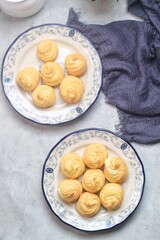 Kue Sus Isi Vla or soes cake (Choux Pastry Cream Puff) is Crispy and airy choux pastry shell are filled with smooth and soft custard cream. served in a plate.
