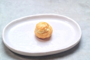 one soes cake (Choux Pastry Cream Puff)  served in a plate.
