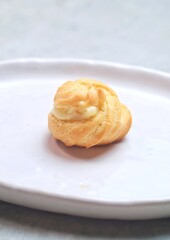 one soes cake (Choux Pastry Cream Puff)  served in a plate.
