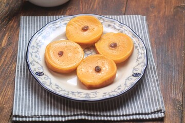 Kue Lumpur or Mud Cake, Indonesian traditional cake made from potato, flour, eggs and coconut milk topped with raisins served on white plate.
