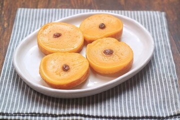 Kue Lumpur or Mud Cake, Indonesian traditional cake made from potato, flour, eggs and coconut milk topped with raisins served on white plate.

