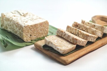 Raw tempeh or tempe. Tempe is fermented soy product originally from Indonesia. Tempe slices. Isolated on white background
