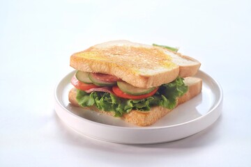 sandwich with smoked beef, lettuce, cucumber and tomato on white plate, isolated on white background. 
