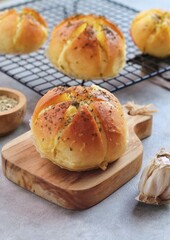 Korean Garlic and Cheese Bread (Yugjjog Maneulppang) is Popular Street Food in Korea. Made from Bread Bun, Cream Cheese, Garlic, Oregano and Honey. Isolated on wodden bowl. Warm ton
