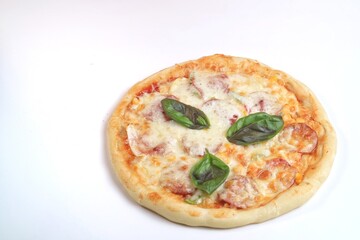 Tasty pepperoni pizza with basil isolates on white background
