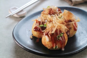 Takoyaki is japanese street food with sauce, mayonaise and katsuobushi as topping and octopus filing, popular street food.