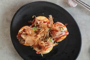 Takoyaki is japanese street food with sauce, mayonaise and katsuobushi as topping and octopus filing, popular street food.