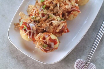 Takoyaki is japanese street food with sauce, mayonaise and katsuobushi as topping and octopus filing, popular street food.