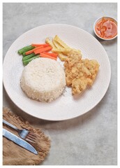 Crispy Chicken Steak with french fries and vegetables and rice
