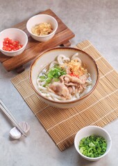 Japanese traditional noodle soup Niku Udon with kakedashi soup, fish stock soup and then topped with sliced beef and sliced scallions.
