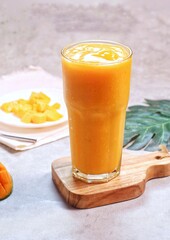 Fresh beautiful delicious mango juice. Close up design concept of smoothie cold drink in glass cup. 
