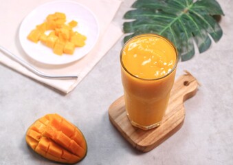 Fresh beautiful delicious mango juice. Close up design concept of smoothie cold drink in glass cup. 
