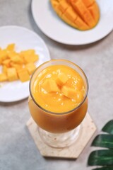 Fresh beautiful delicious mango juice. Close up design concept of smoothie cold drink in glass cup. 

