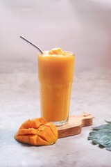 Fresh beautiful delicious mango juice. Close up design concept of smoothie cold drink in glass cup. 
