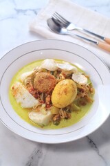 Lontong Sayur Medan, Traditional Indonesian food, in a bowl. Its coconut broth with vegetable,rice cake, egg, 'rendang' chili, rice crackers' krupuk' popular dish in Medan, North Sumatra.