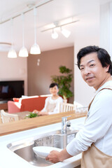 皿洗をする男性と寛ぐ女性