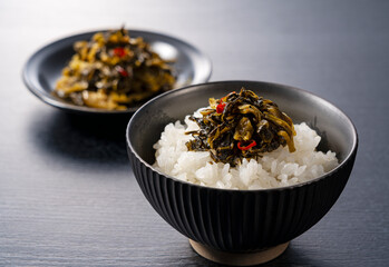 Karashi Takana on Rice on a Black Background – Karashi Takana: A Japanese-Style Pickle Made from Mustard Greens