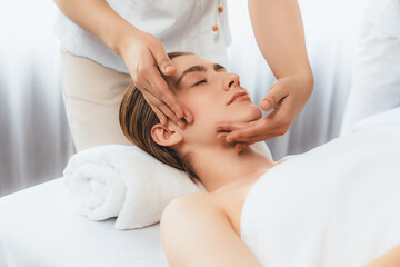 Fototapeta na wymiar Caucasian woman enjoying relaxing anti-stress head massage and pampering facial beauty skin recreation leisure in dayspa modern light ambient at luxury resort or hotel spa salon. Quiescent