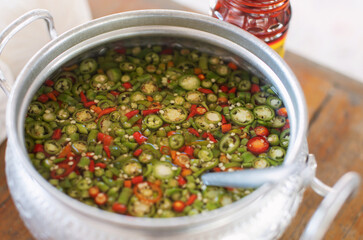 Sliced chilli peppers in vinegar in a metal container