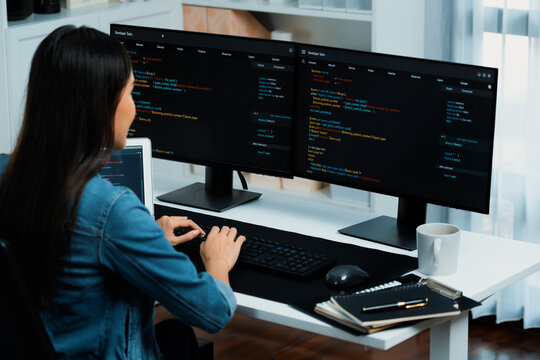 Young Asian in IT developer creating with typing online information on pc with coding program data of website application, wearing jeans shirt. surrounded by safety analysis two screens. Stratagem.