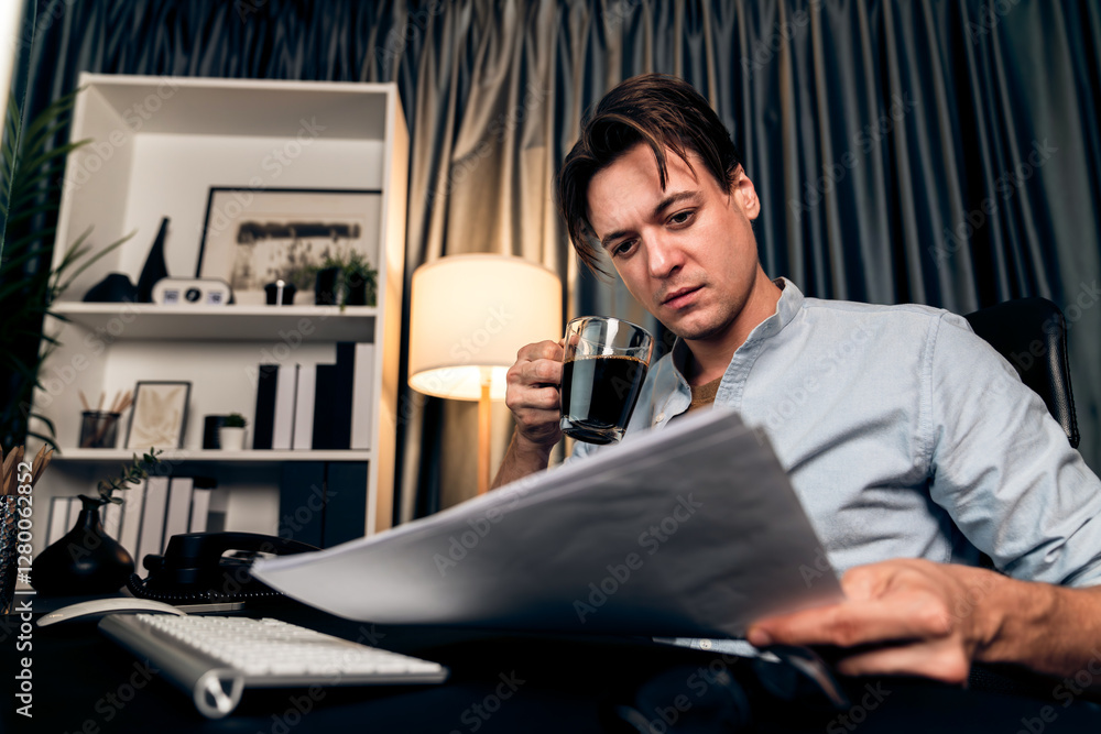 Aufkleber sales manager working on pc and compare with business graph report while drinking coffee at night ti