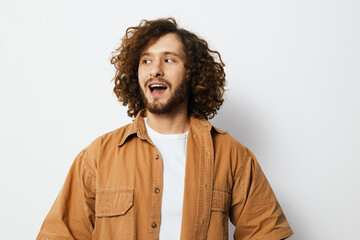 Young man with curly hair smiling in casual attire, showcasing a cheerful expression against a light background, ideal for lifestyle and fashion concepts