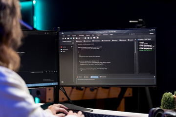 Engineer working from home developing software in Java programming language using computer monitor....
