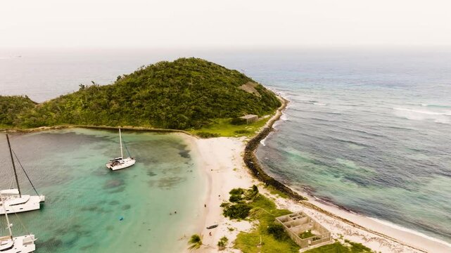 Aerial view of Mayreau in St. Vincent and the Grenadines, overlooking the isthmus and beach, waves crashing