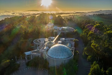 Aerial view of the  Chabot Space & Science Center at sunrise, showcasing the unique architecture and surrounding forest. Beautiful morning light illuminates the structures.,Oakland, California, USA