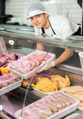 Salesman showcases selection of sausages to help customer make choice.