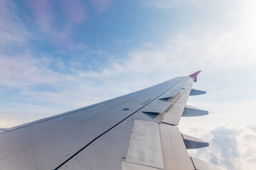 View from the airplane window at a beautiful cloudy sky and the airplane wing
