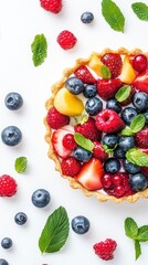 Obraz premium A delicious fruit tart showcases a variety of fresh berries and mint leaves, perfect for dessert