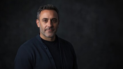 Naklejka premium Confident Middle-Aged Man in Casual Attire Against a Dark Background