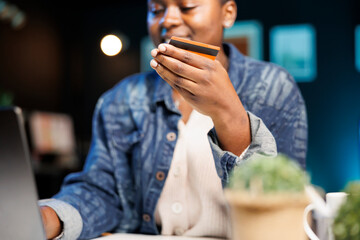 Closeup of african american woman utilizing digital laptop for online shopping and confidently...