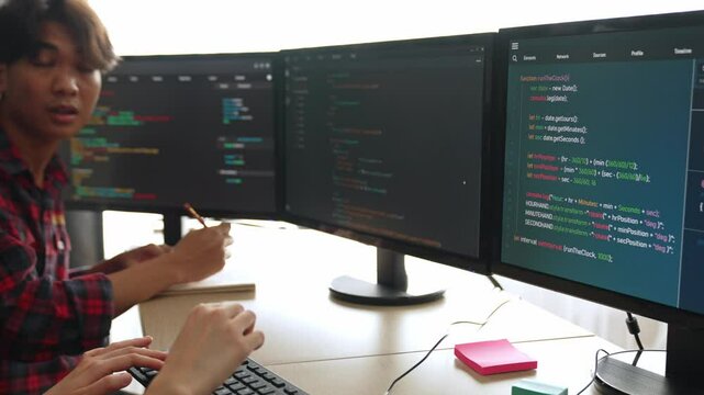 Slow motion back end software developer engineer for computer programming working together on debugging writing computing code, solving complex algorithms display on monitor in office. Burgeoning