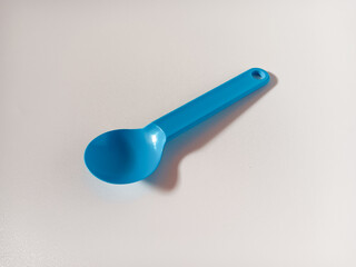 Close up of blue plastic spoon isolated on white background.