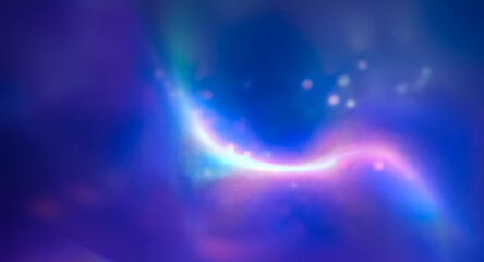 Obraz premium Abstract blurry image features a bright curved rainbow light set against a dark blue and purple backdrop. Bokeh effect creates a soft, dreamy feel.