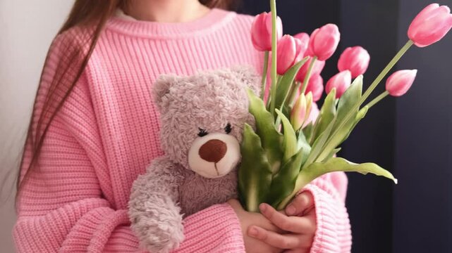 Заголовок	
Flowers are fragrant. Children's hands hold bouquet of pink tulips and teddy bear. Concept of spring and Women's Day and March 8th.