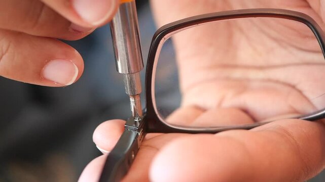 Repairing eyeglasses with careful precision at a workshop